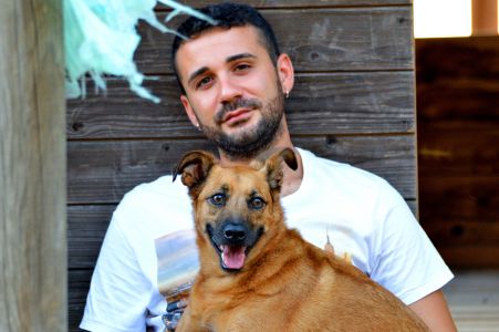 L'educatore di cani Marco Zongoli abbraccia un cane